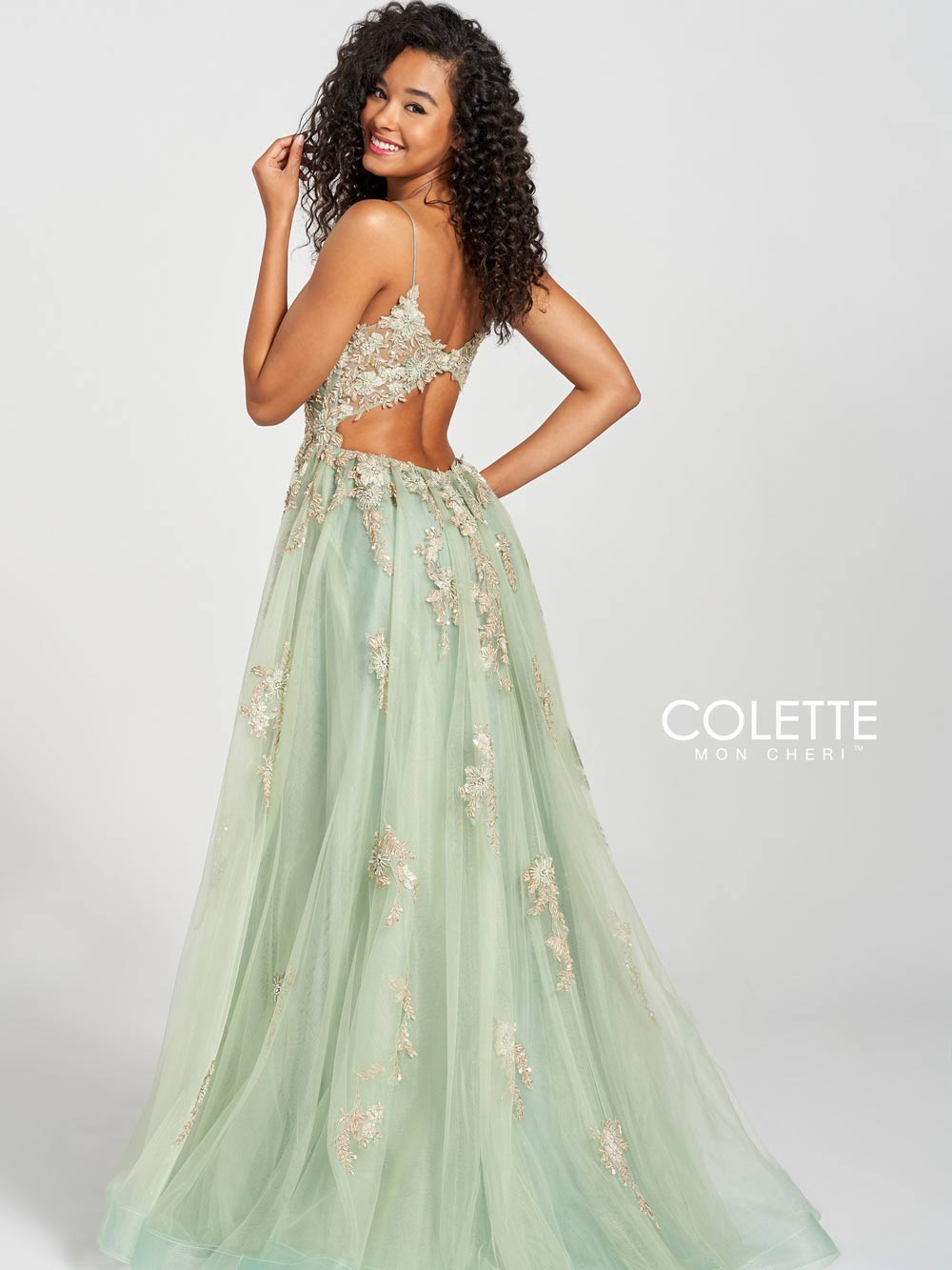 black curly haired model wearing an ivy prom dress. photo taken from the backside of the model