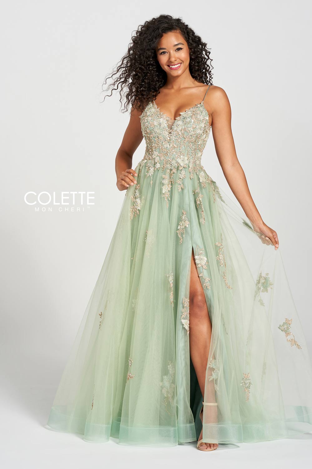 Black curly haired model faced forward wearing ivy prom dress